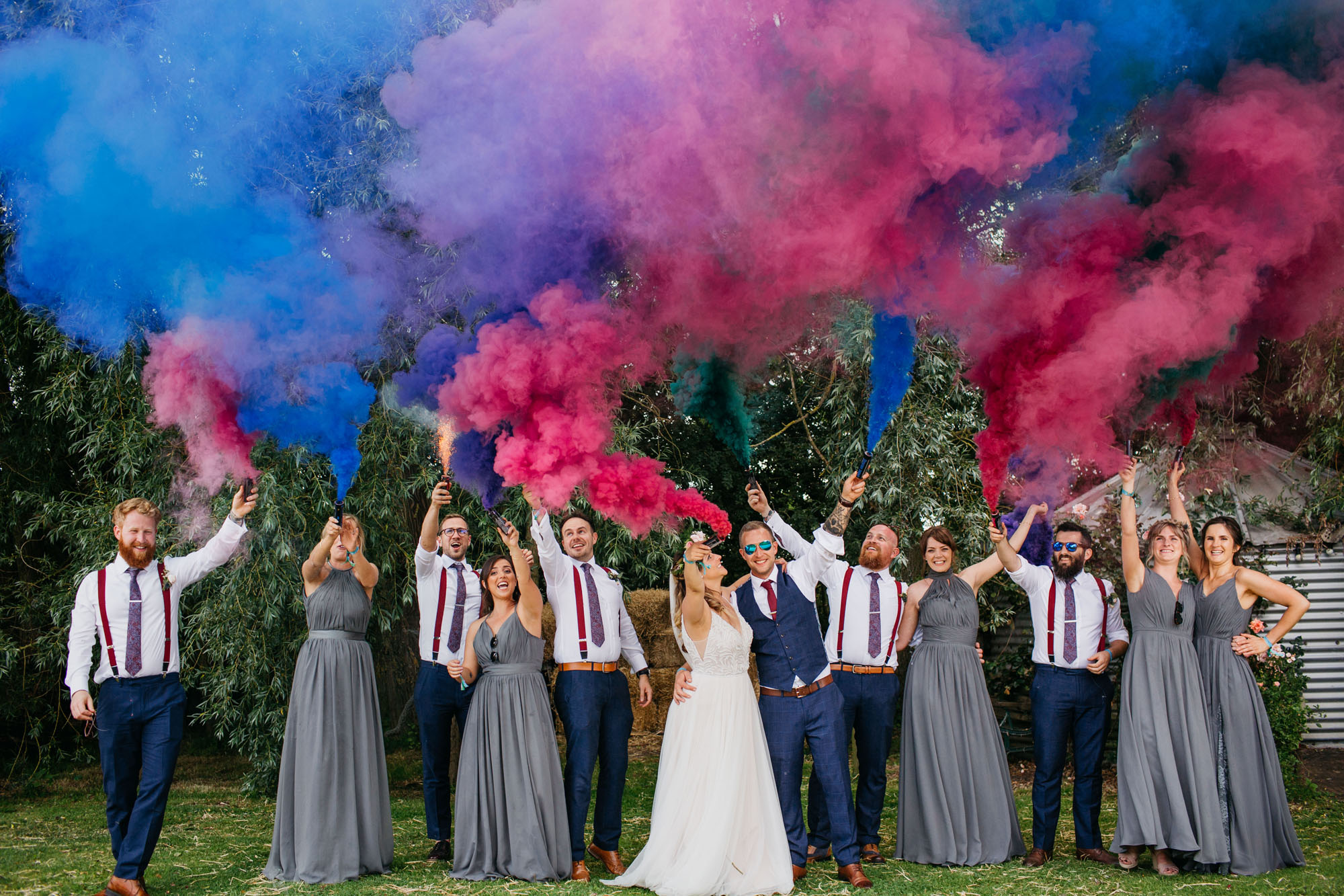 Yorkshire wedding photography of Alicia and Phil. She wears a white boho style dress and he's in a blue ckech suit. She has a full flower crown in delicate pinks, and they look happy. Image by John Hope Photography